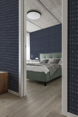 Navy wallpaper with thin, uneven vertical brush stroke patterns in white, creating a dynamic and modern look in a bedroom with traditional wallpaper.