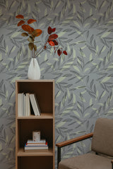 Self-adhesive wallpaper with a neutral leaf stencil design in muted tones of grey and green. The pattern includes various leaf shapes scattered across the wall, creating a natural and subtle backdrop.