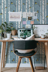 Self-adhesive Winter landscape wallpaper with birch trees, yellow birds, and a muted blue-grey background, creating a serene and cozy atmosphere.