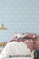 Light blue wallpaper adorned with intricate white floral patterns and detailed birds among delicate branches and leaves, conveying a classic and elegant style, traditional wallpaper.