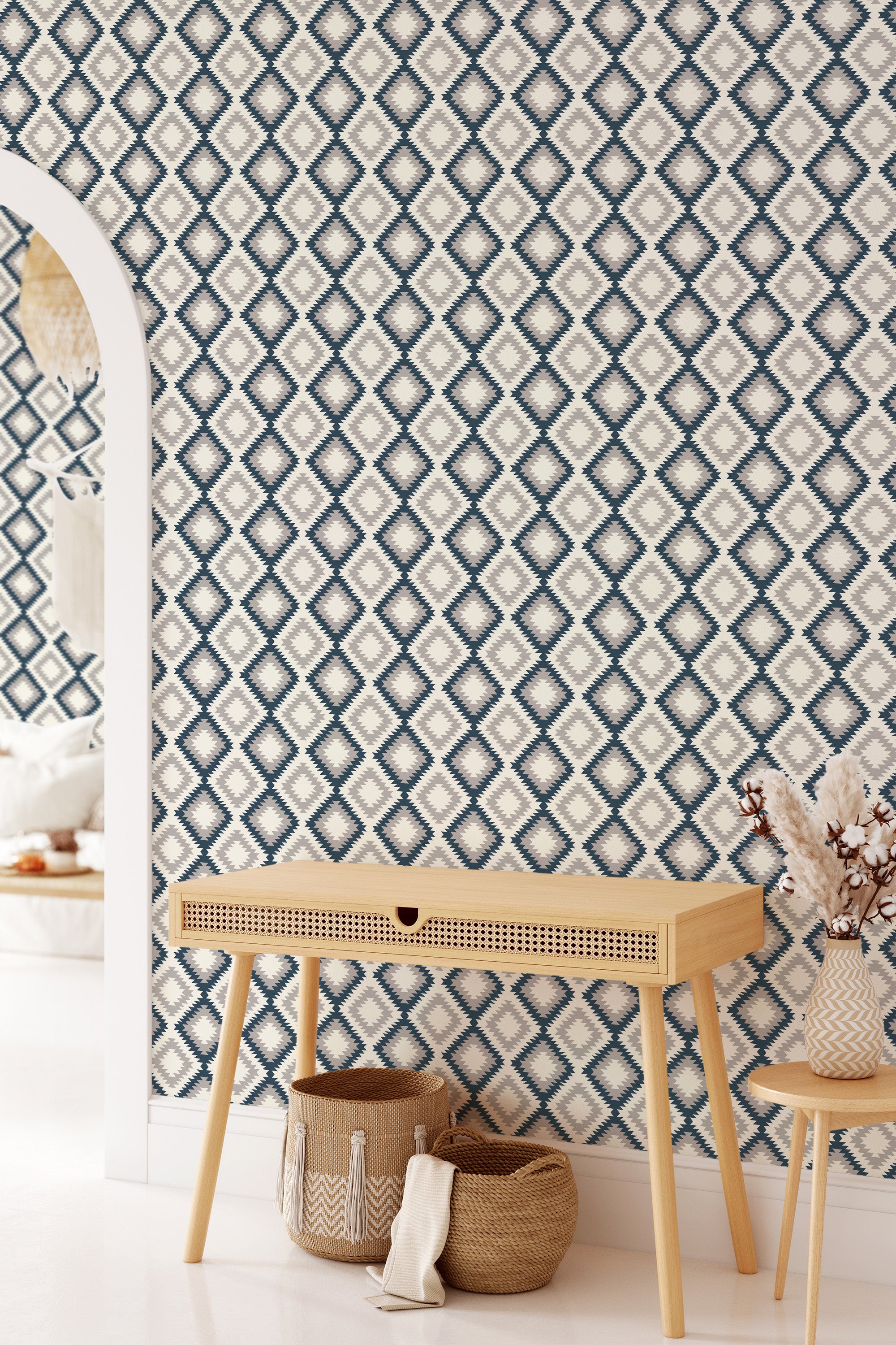 A wall covered with Aztec geometric wallpaper featuring diamond patterns in navy blue and cream colors, creating a repeating intricate design that adds texture and a traditional touch to the room. Traditional wallpaper.