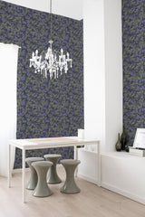 Wallpaper with dark green leaves and clusters of blueberries against a deep blue background, creating a lush, nature-inspired pattern in a traditional wallpaper.