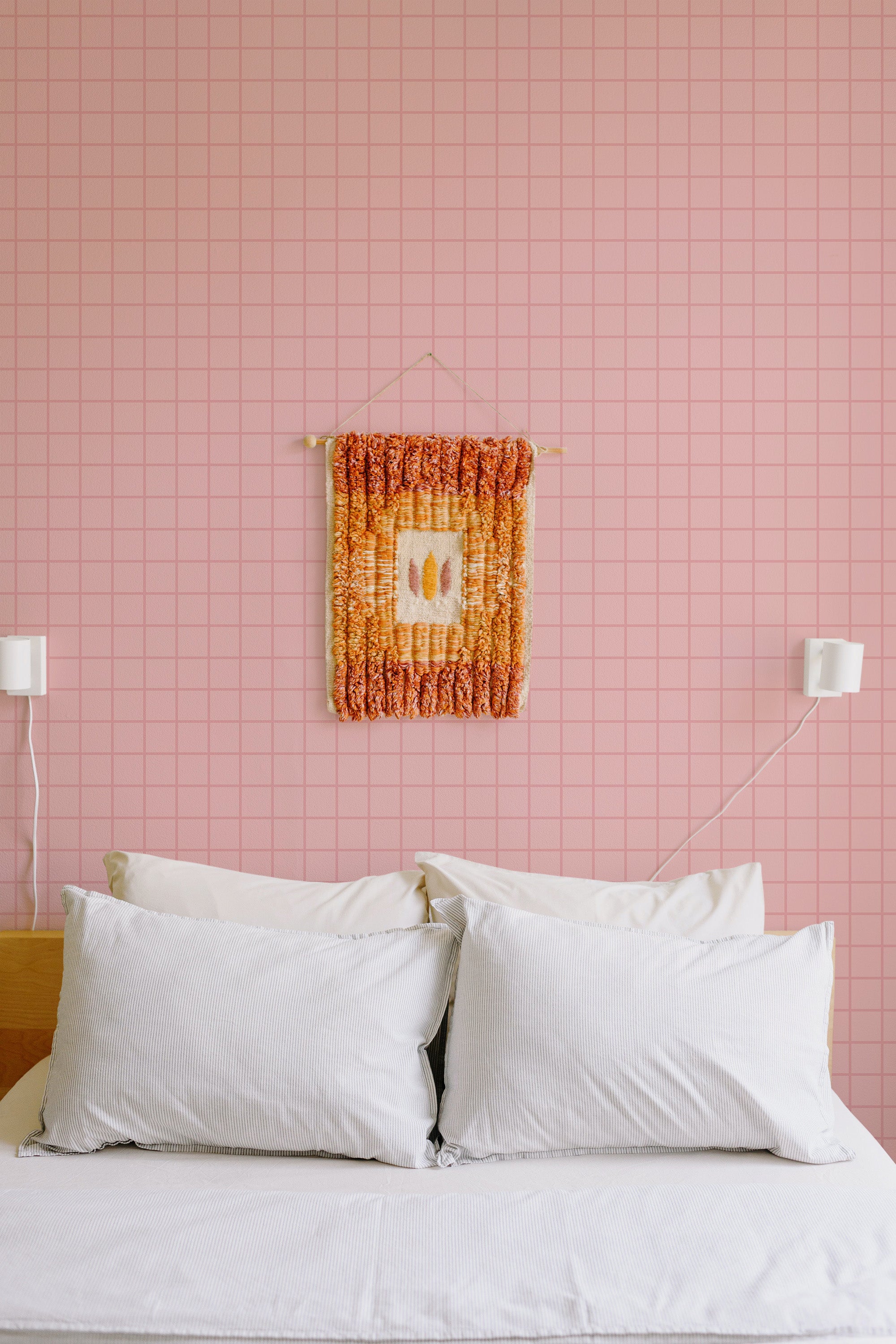 Self-adhesive wallpaper with a baby pink plaid pattern in a grid design covering the entire wall.