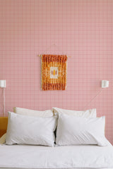 Self-adhesive wallpaper with a baby pink plaid pattern in a grid design covering the entire wall.