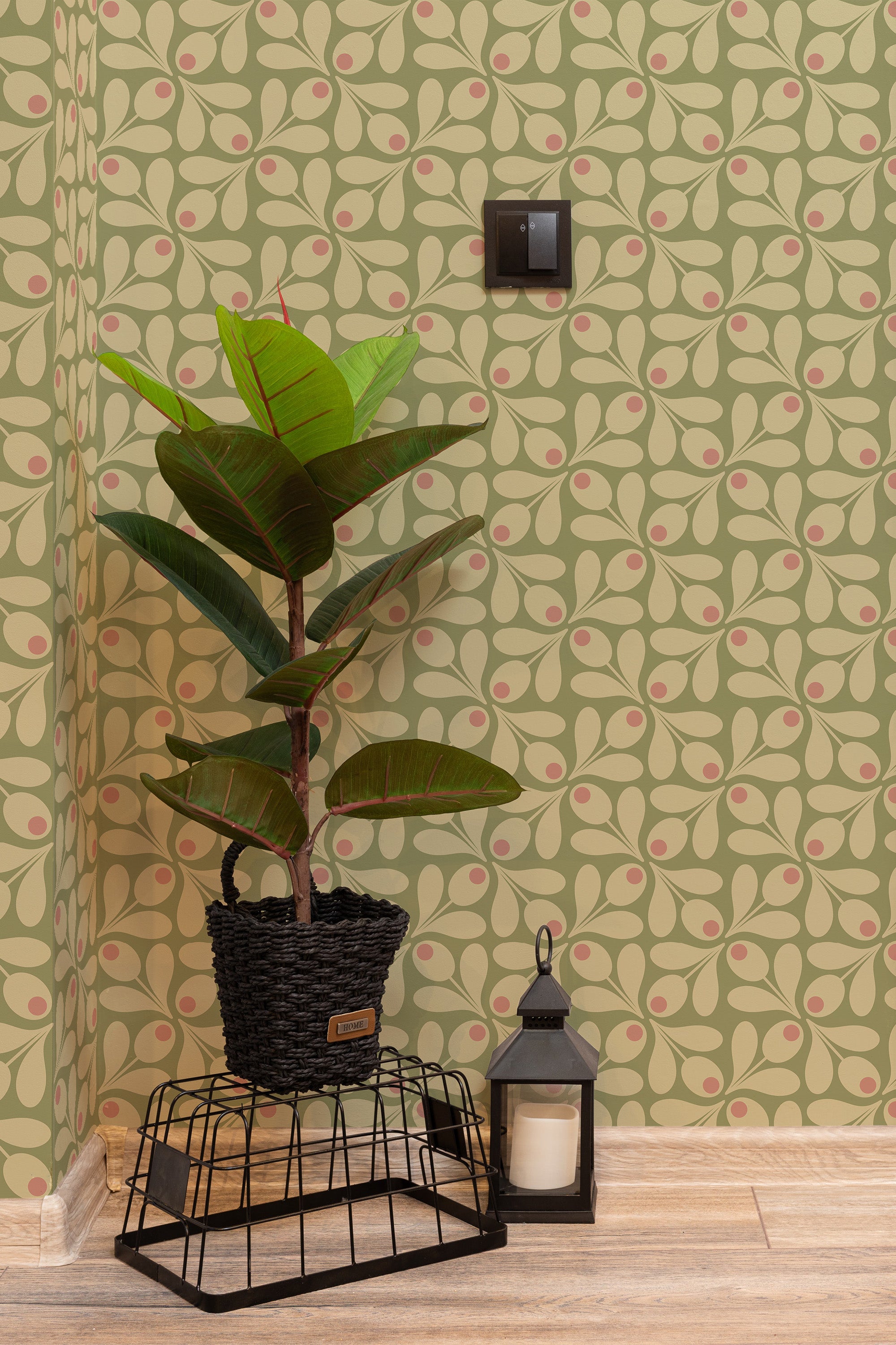 Self-adhesive wallpaper in a Green 60s pattern with overlapping retro-style leaves in olive green, cream, and pink hues creating a geometric and organic design on the wall.