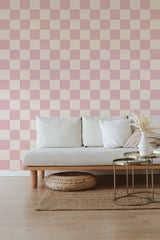 Wallpaper with a pattern of alternating pink and off-white squares, creating a checkerboard effect, with soft and muted tones offering a subtle, cozy aesthetic. Traditional wallpaper.