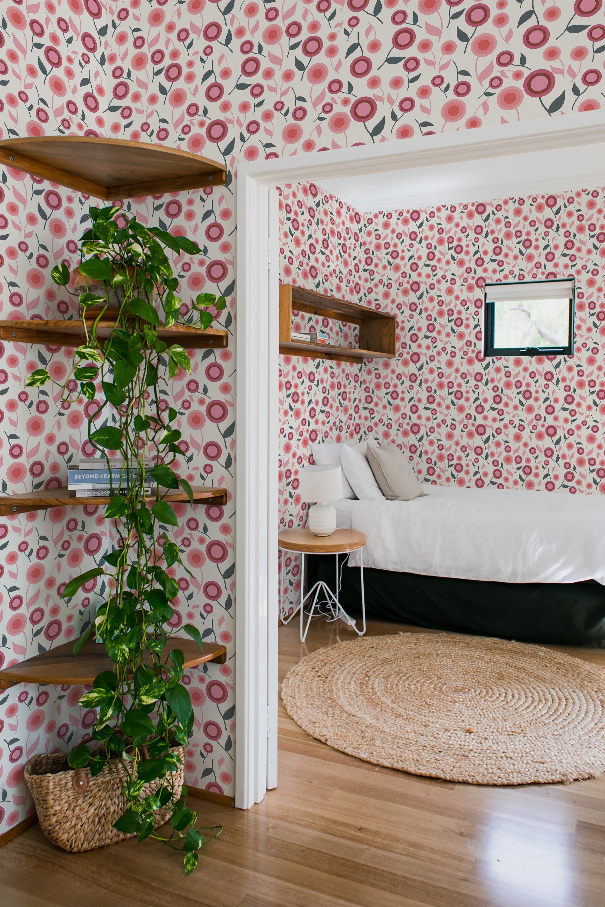 A room adorned with floral wallpaper in shades of pink, red, and pale peach, interspersed with green leaves and gray branches, creating a vibrant and lively atmosphere within the space. Traditional wallpaper.
