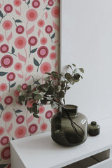 Self-adhesive wallpaper with a playful design of pink and red stylized flowers and green stems on a light beige background.
