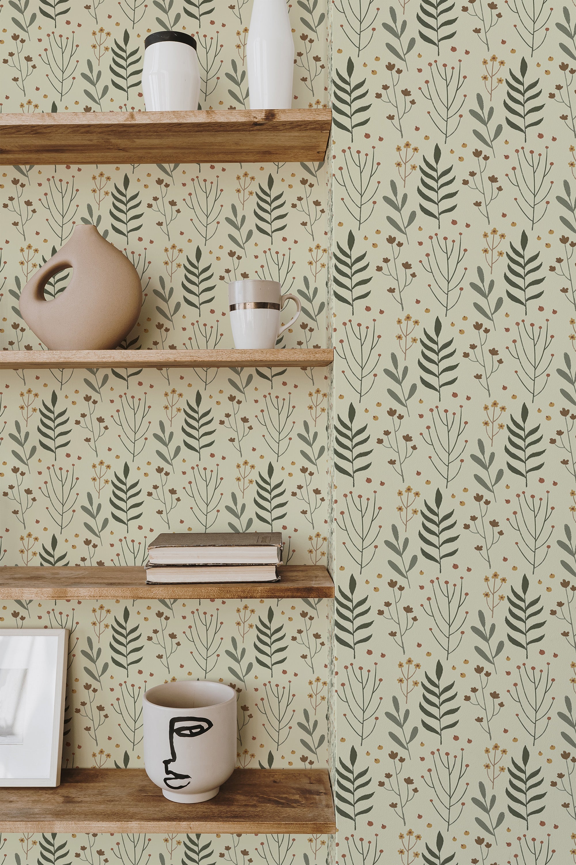 Self-adhesive earthy Scandinavian leaf wallpaper in soft greens and muted yellows with a delicate pattern of stylized leaves and small blossoms, creating a natural and minimalistic ambiance in the room.