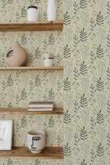 Self-adhesive earthy Scandinavian leaf wallpaper in soft greens and muted yellows with a delicate pattern of stylized leaves and small blossoms, creating a natural and minimalistic ambiance in the room.