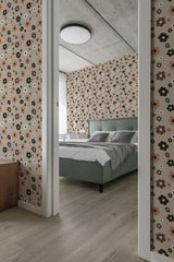 Room with beige 70s retro wallpaper adorned with geometric flower patterns in shades of green, brown, and orange, creating a vintage aesthetic on traditional wallpaper.