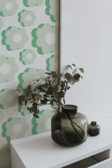Self-adhesive wallpaper with a Green retro flower pattern featuring oversized, stylized flowers in various shades of green and white, creating a vintage, mid-century vibe.