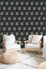 A room with Blue Bold geometric wallpaper in a repeating pattern of dark blue, grey, and white cubes creating a three-dimensional effect on the wall, paired with light-colored furniture and a neutral-toned rug. Traditional wallpaper.