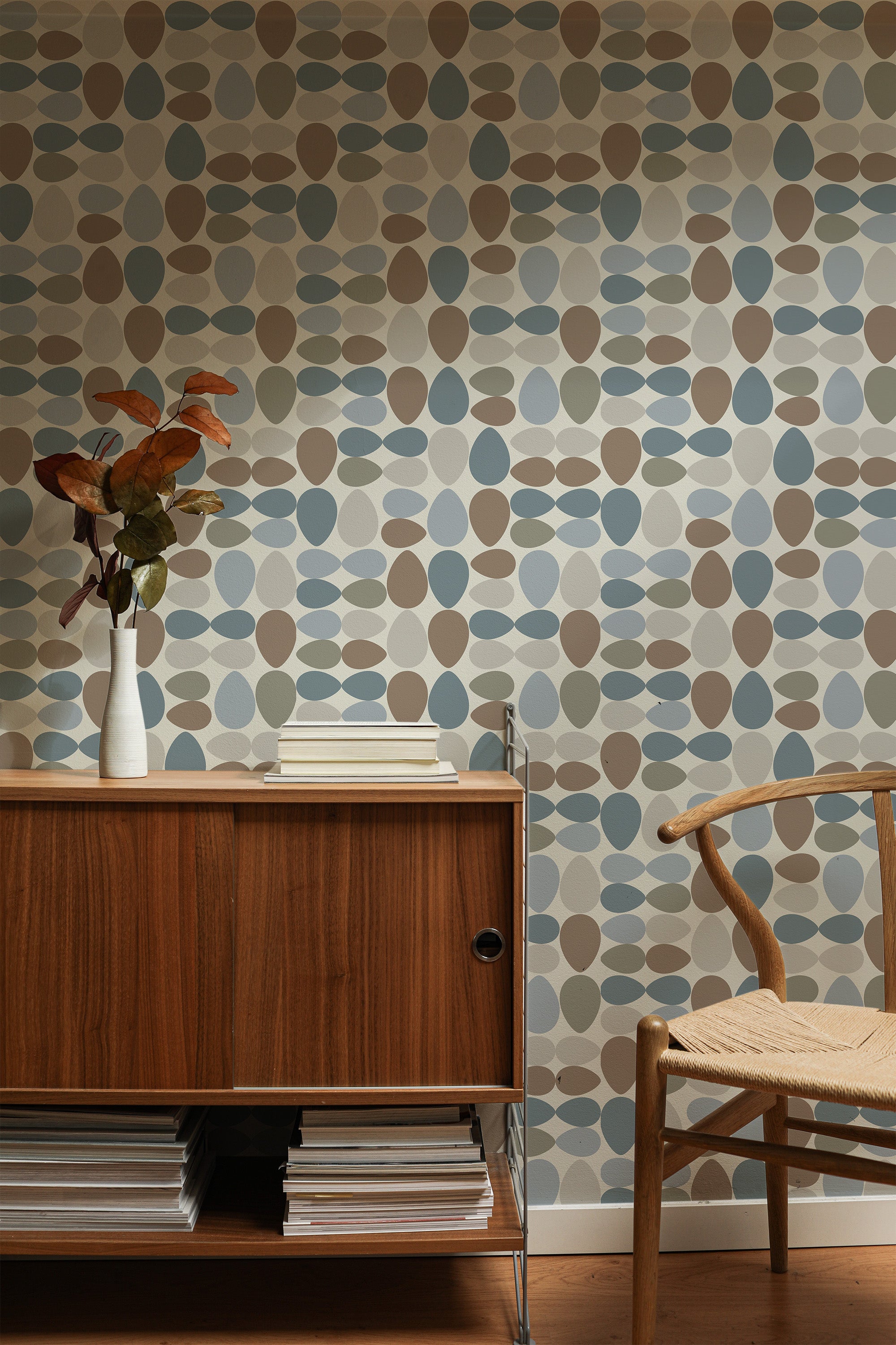 Self-adhesive wallpaper with a Mid-century eggs design displaying overlapping oval shapes in shades of blue, beige, brown, and cream, creating a retro and geometric pattern.