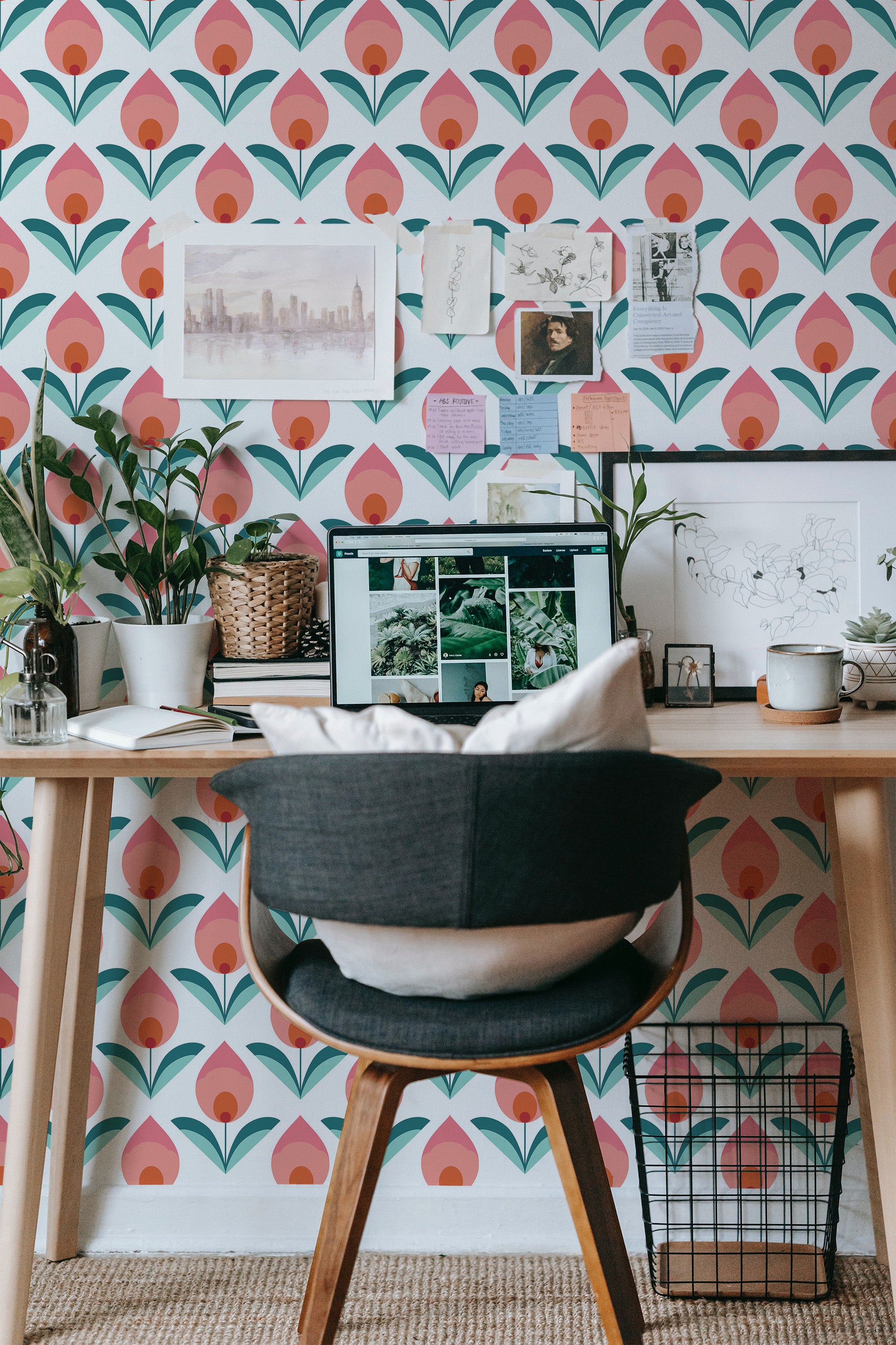 Self-adhesive Retro Tulip wallpaper in pink and green tones, in a repeating pattern of stylized tulip flowers, covering a wall behind a wooden desk.