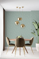 Green wallpaper adorned with a pattern of small, minimalist cactus illustrations. A subtle desert vibe fills the room with its muted green hue and delicate, repeating cactus motif, bringing nature indoors with this traditional wallpaper.