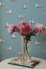 Self-adhesive wallpaper in a sailboat design on a light blue background, adorned with illustrated white and gray sailboats of various sizes.