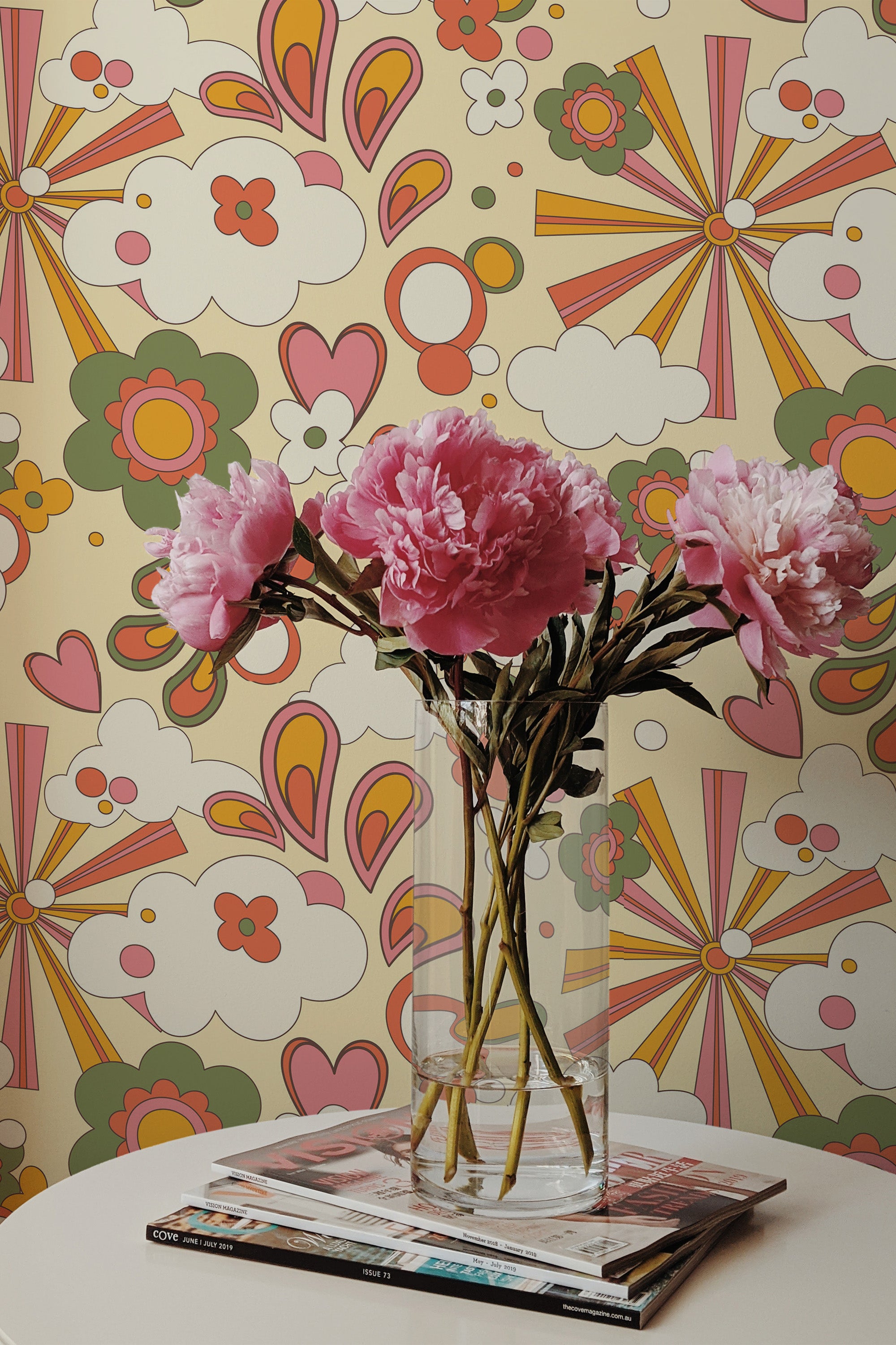 Self-adhesive wallpaper with a playful Groovy design in vibrant colors, including pink, orange, and yellow. The pattern includes stylized flowers, hearts, and abstract shapes arranged in a whimsical, retro-inspired style.