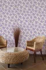 Self-adhesive wallpaper with a pattern of scattered purple flowers and green stems, creating a lively and natural ambiance in the room, paired with rattan furniture.