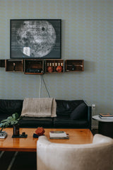 A room with a wall covered in dark houndstooth pattern wallpaper. The wallpaper has a subtle repeating geometric design in dark shades, giving the room a sophisticated and modern look. This pattern contrasts elegantly with the room's neutral and warm-toned furnishings, adding depth and texture to the space. Traditional wallpaper.