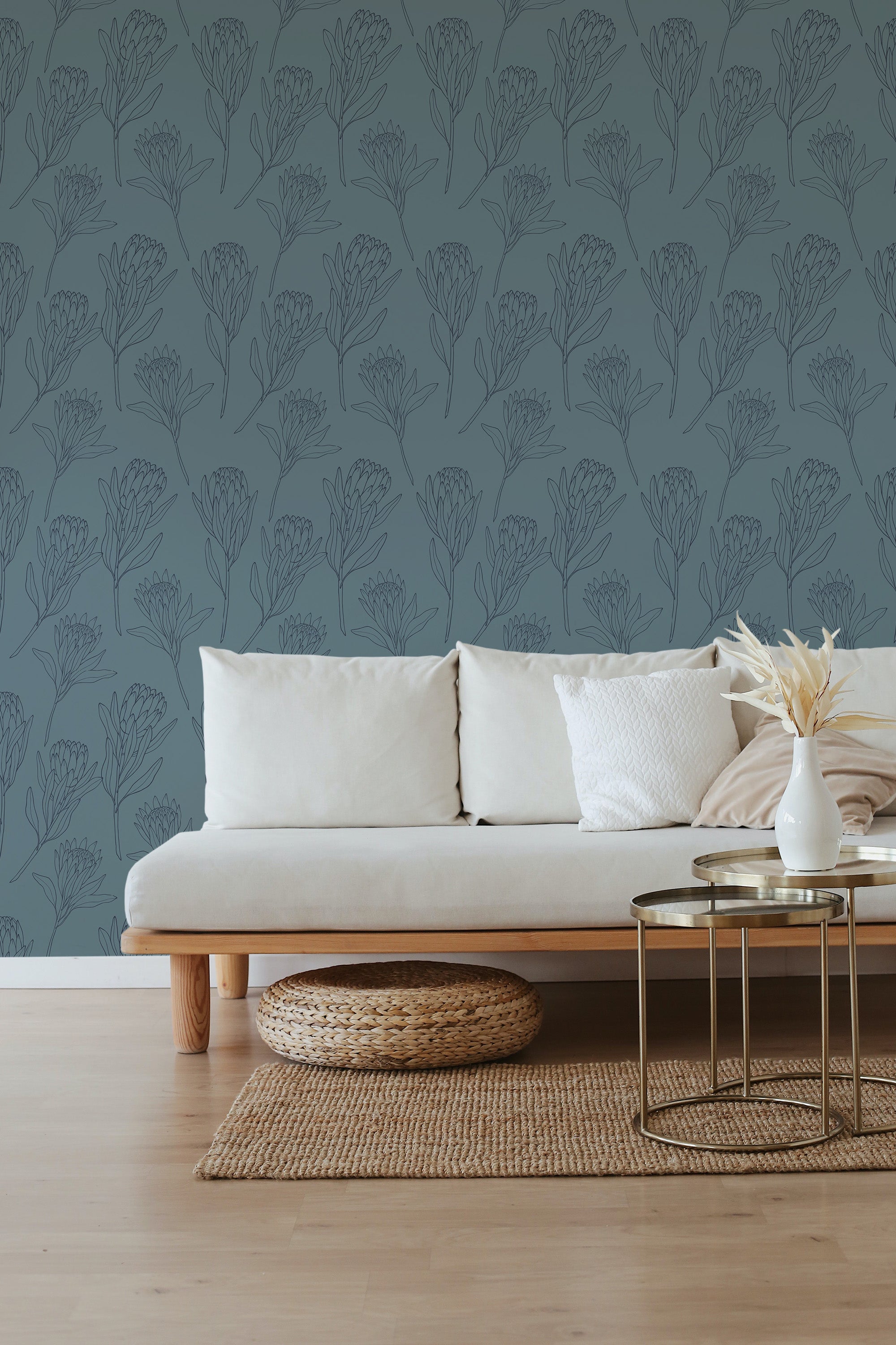 A room with blue wallpaper adorned by a subtle line art pattern of Protea flowers, complementing the neutral-toned furnishings. Traditional wallpaper.