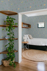 Room with a light gray-blue wall adorned with delicate multicolored wildflowers, creating a vibrant yet serene ambiance. Traditional wallpaper.