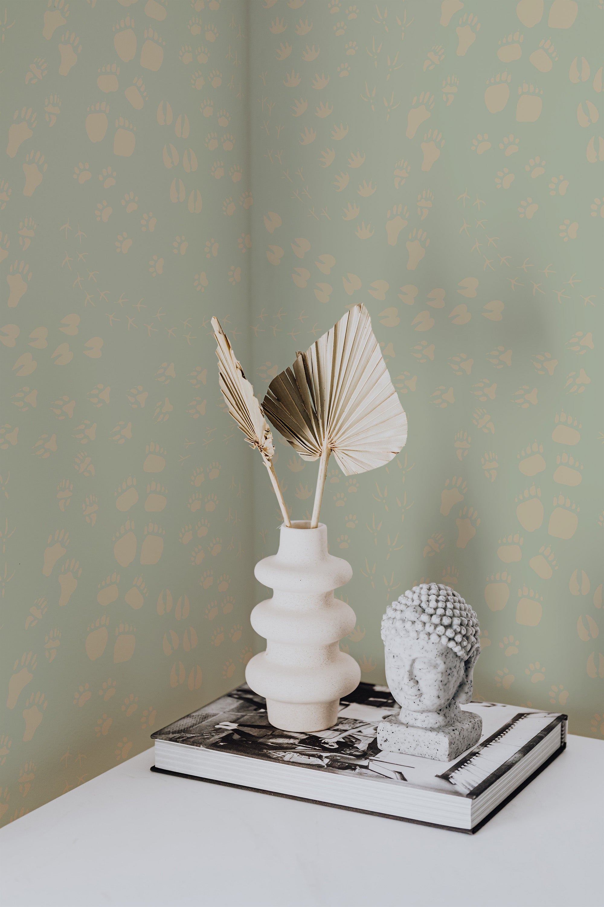 Self-adhesive wallpaper with animal footprints pattern in beige on a soft green background, adding a playful and subtle natural accent to the room.