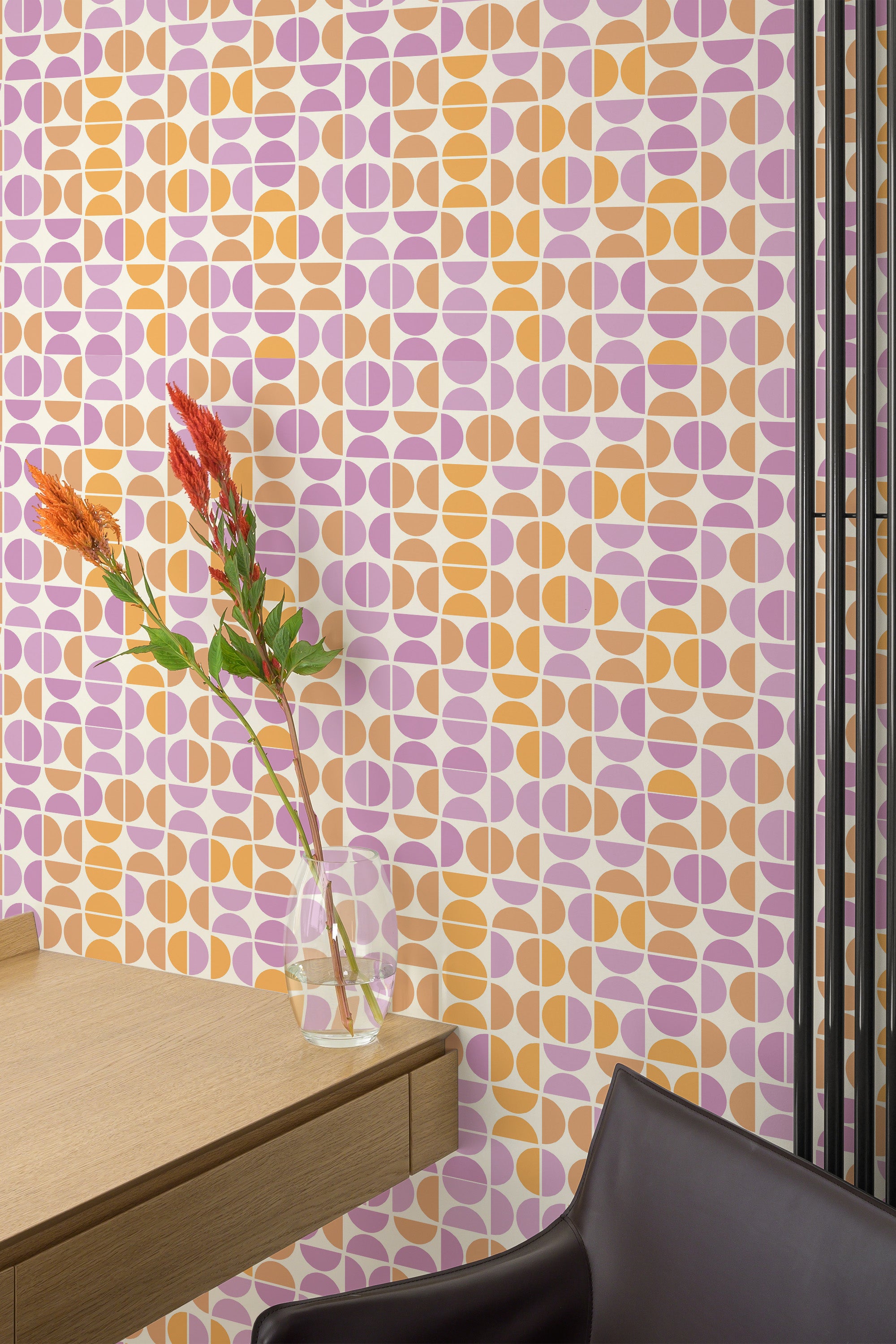 Self-adhesive wallpaper with a pink and orange mid-century design featuring a repeating geometric pattern of ovals and shapes.