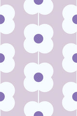 The wallpaper shows a repeating pattern of simple, stylized white flowers with purple centers set against a light purple background. The flowers are arranged in vertical rows, creating a retro floral pattern. Peel and stick removable wallpaper.