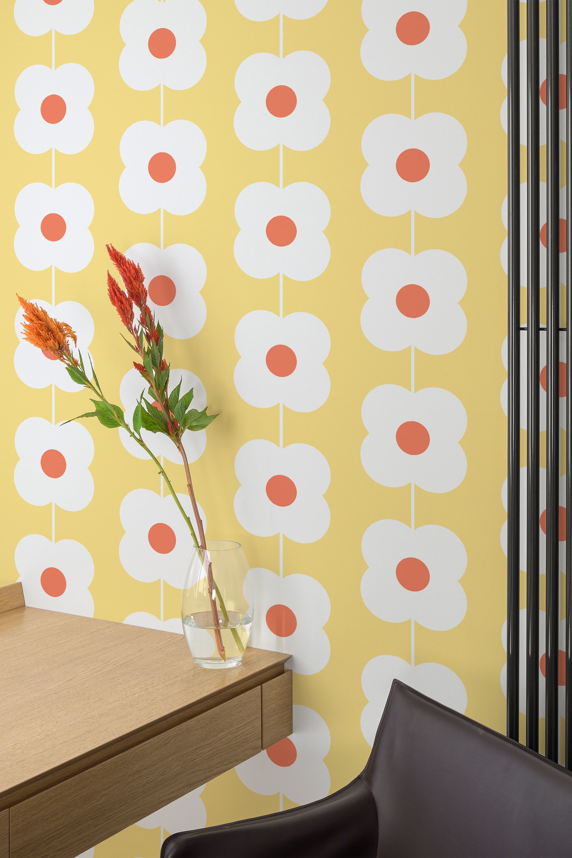Self-adhesive yellow floral line wallpaper with a retro-inspired pattern of white flowers, each with a bold red center, against a soft yellow background.