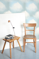 Self-adhesive Bay Clouds wallpaper with soft, fluffy white clouds floating against a pale blue sky background.