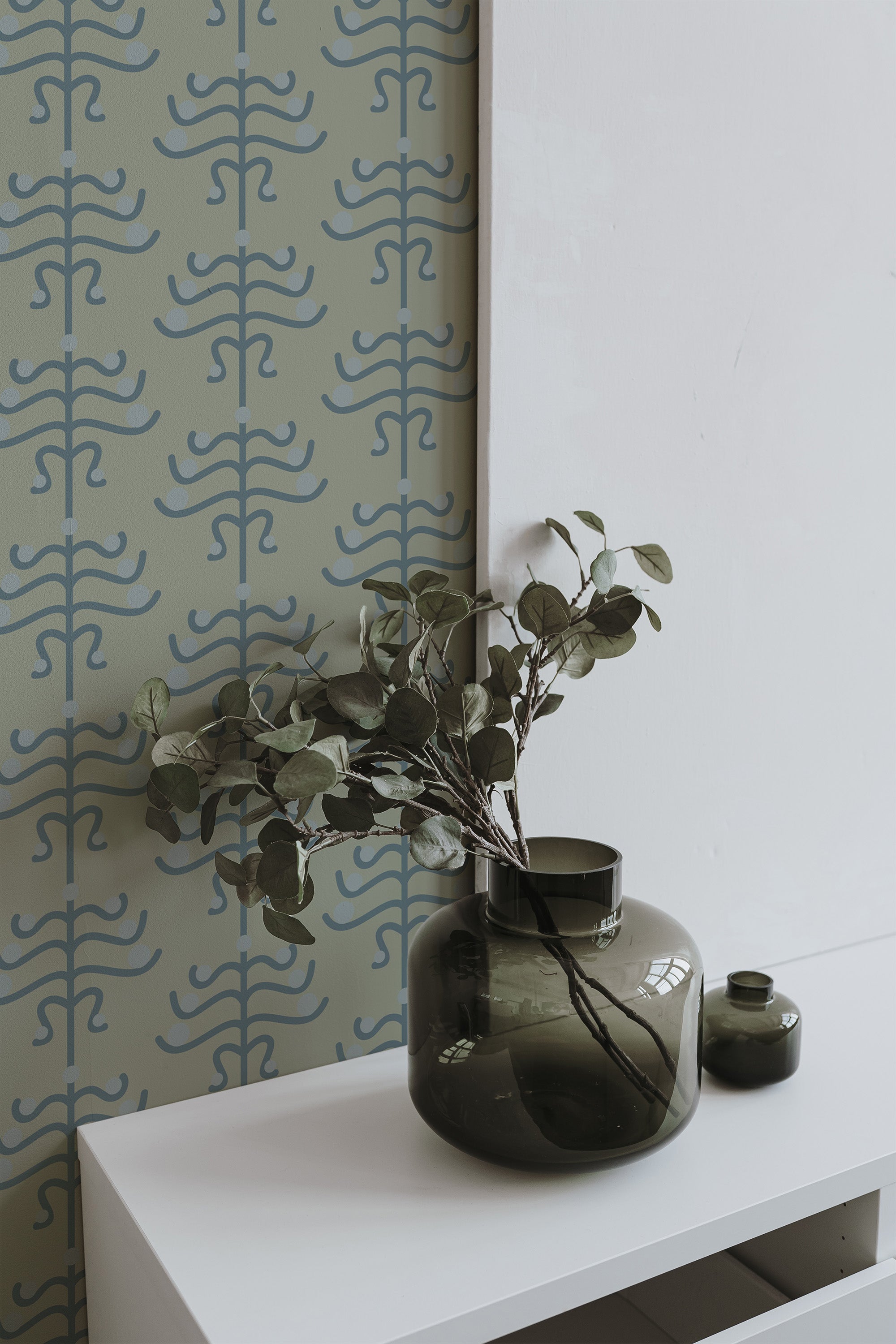 Self-adhesive geometric floral Art Deco wallpaper in soft green, with delicate blue abstract floral patterns, adding a vintage-inspired elegance to the room.