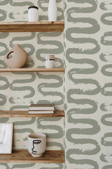 Self-adhesive wallpaper with a Wiggle brush lines design in green and beige hues, creating a fluid, artistic pattern on a light background, adding a modern and whimsical touch to the interior space.