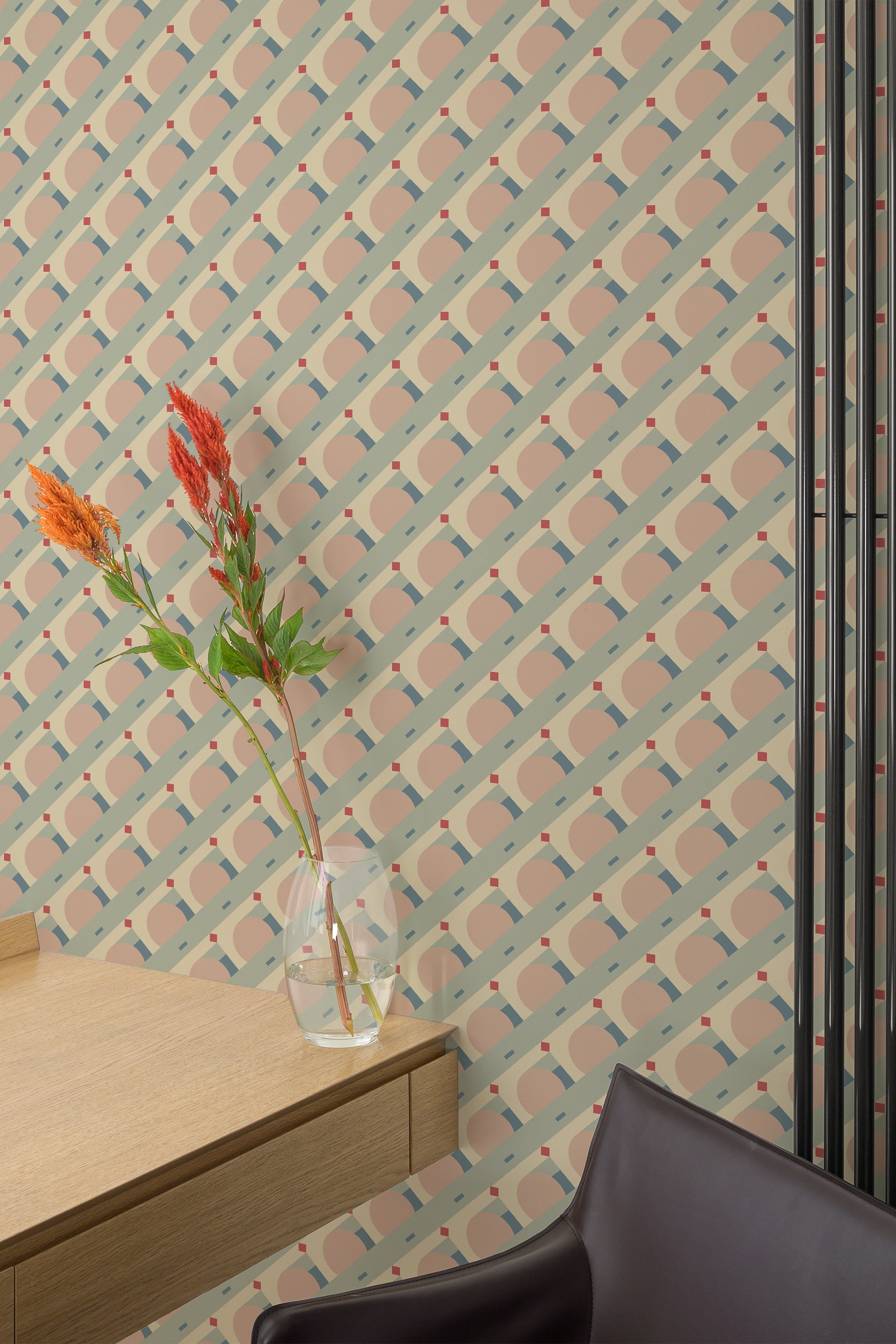 Self-adhesive vintage geometric wallpaper with pastel colors and interlocking shapes on a bedroom wall, complemented by a vase of flowers on a wooden table.