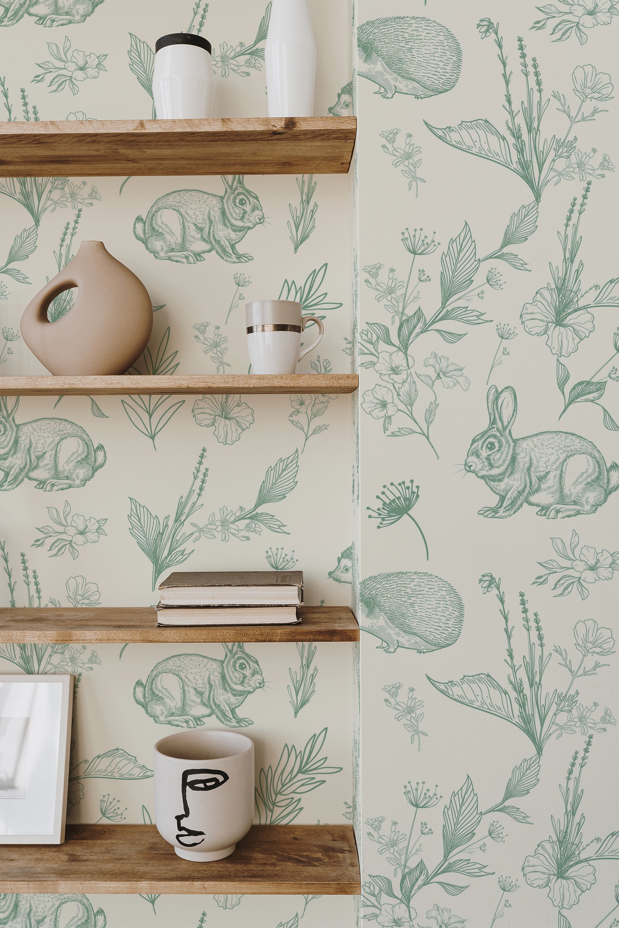 Self-adhesive Sage nursery forest wallpaper with illustrations of various animals and plants in a delicate green hue on a light background, giving a natural and whimsical touch to the room's decor.