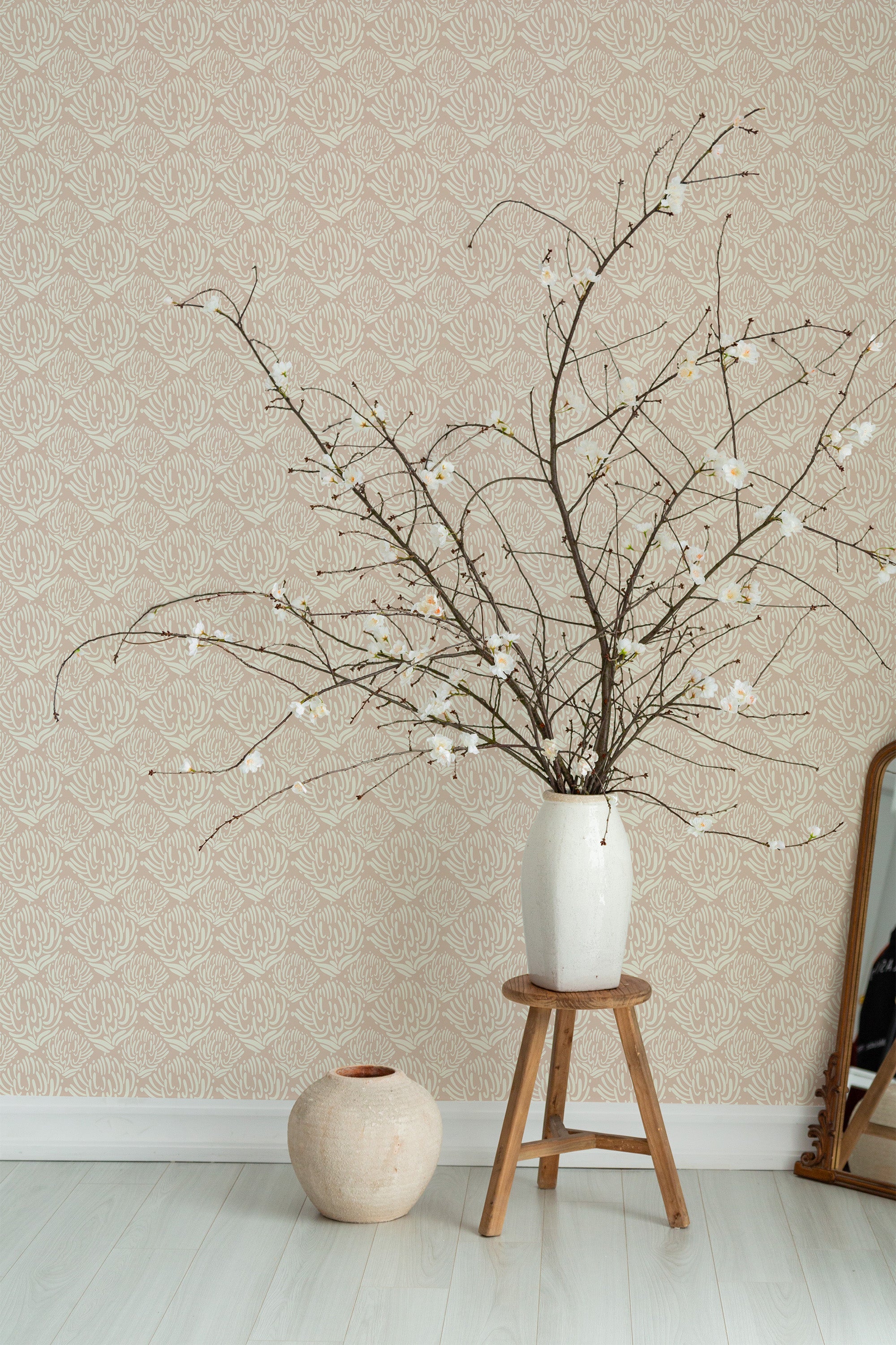Self-adhesive wallpaper with an abstract coral pattern in a neutral color scheme on a room wall, complemented by a vase of branches on a stool.