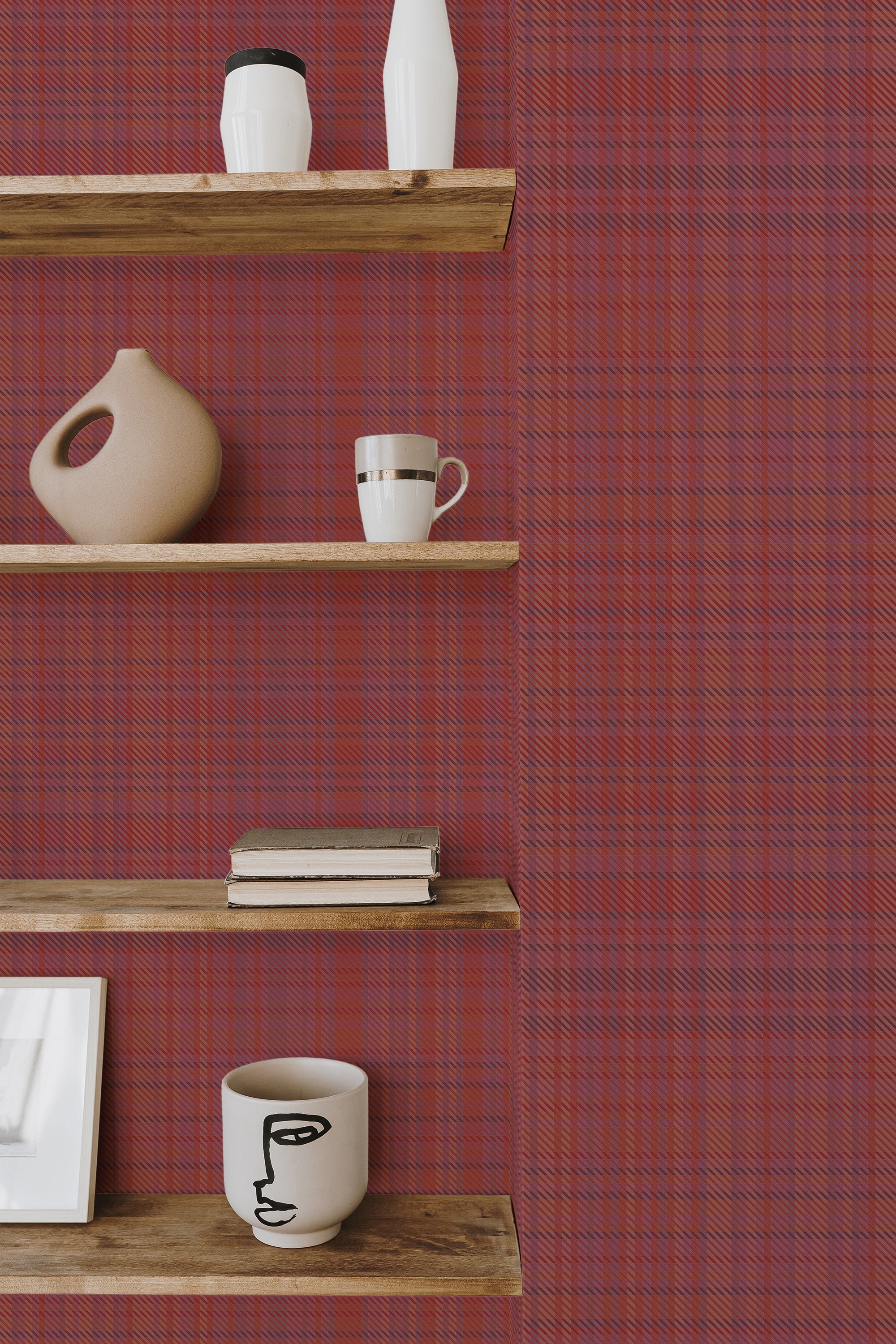 Self-adhesive wallpaper with classic red plaid pattern on a room wall, accentuated by wooden shelves holding various decorative items.