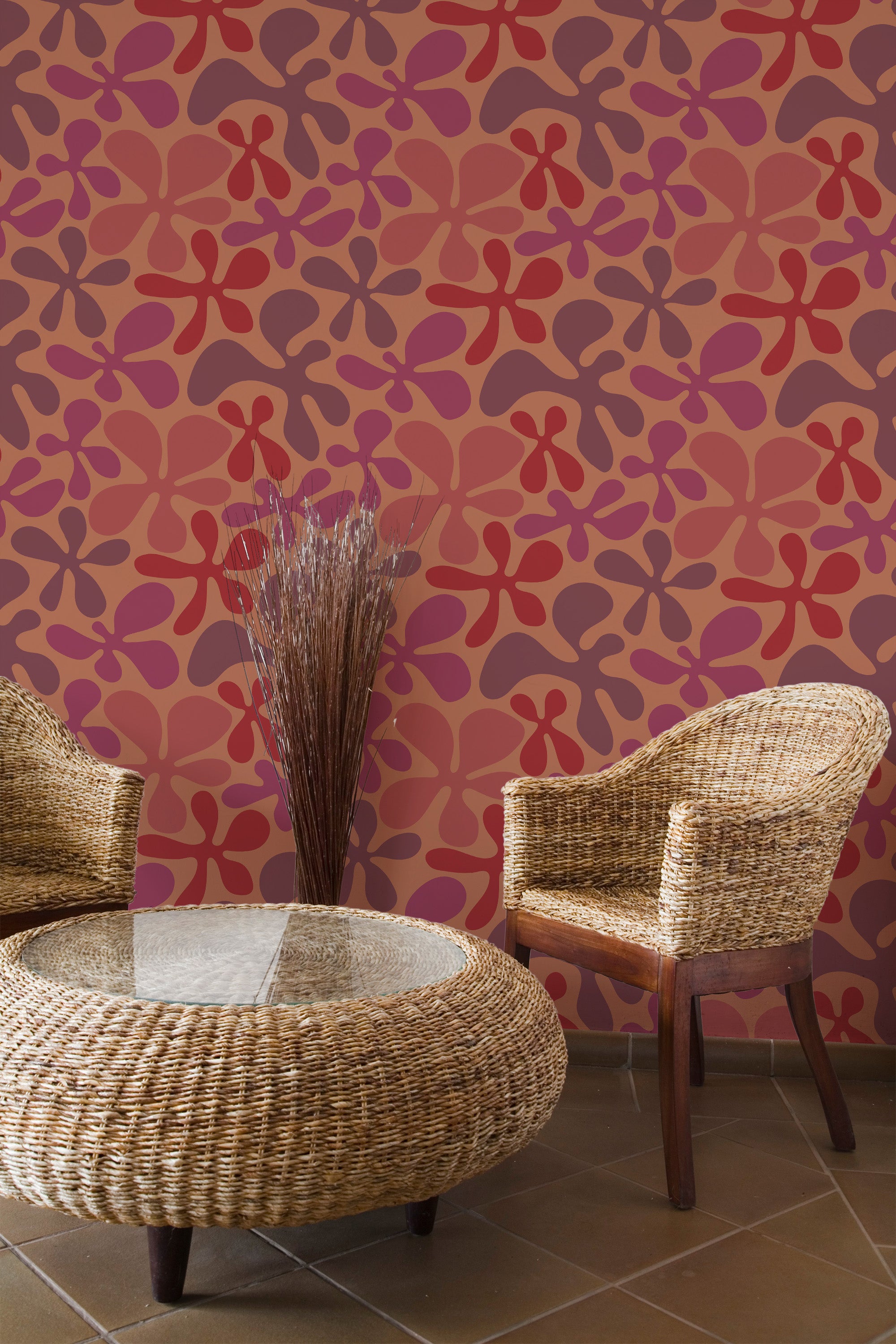 Self-adhesive red floral shapes wallpaper with a repetitive pattern on a room wall, complemented by wicker furniture and a glass-top table.