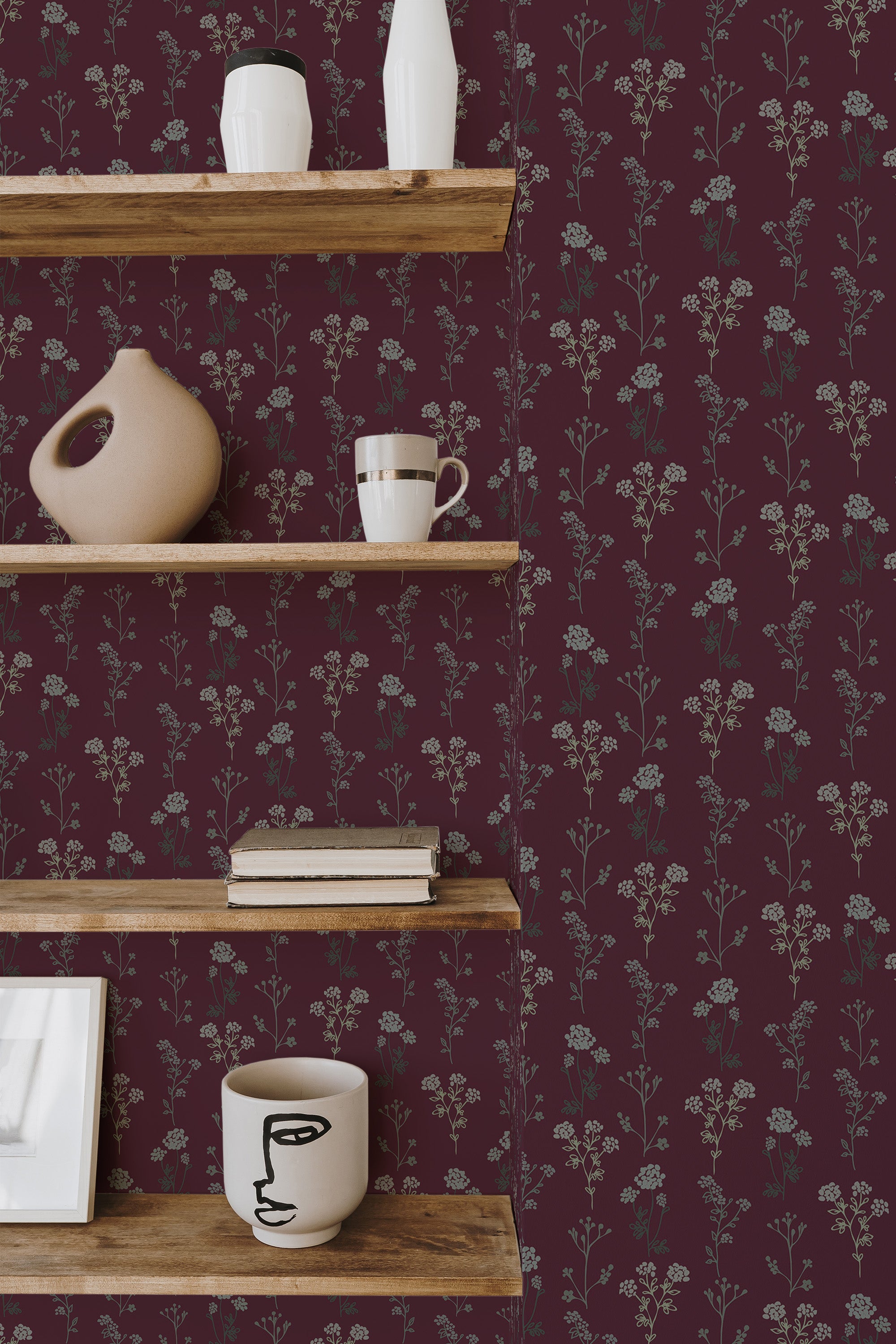 Self-adhesive dark burgundy wallpaper with floral pattern, including small, delicate flowers and leaves, on a wall with wooden shelves displaying various items.