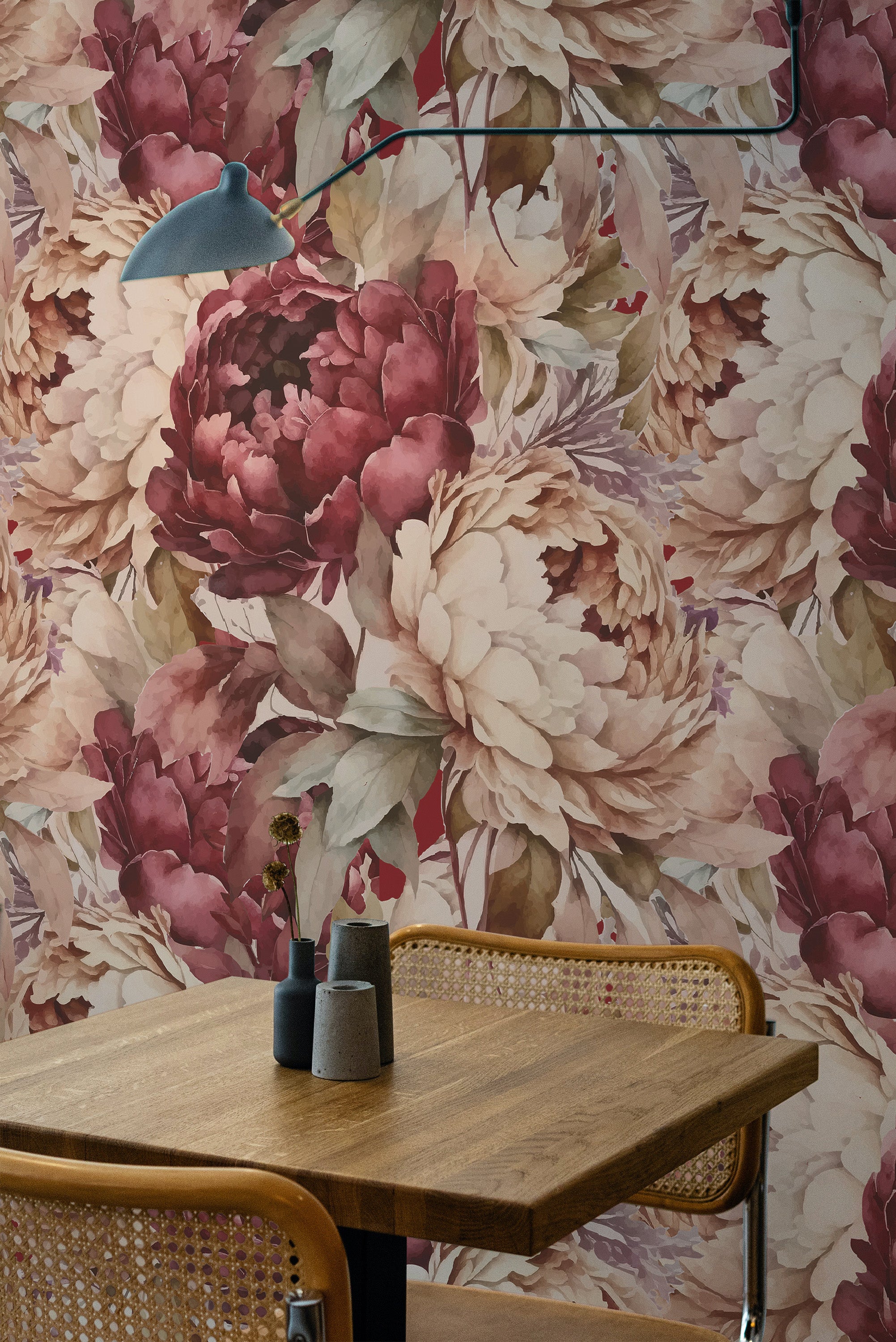 Self-adhesive dark burgundy botanical wallpaper with large floral patterns in shades of pink and cream, accentuating a cozy dining area.