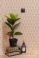 Self-adhesive wallpaper with a geometric retro flower pattern in shades of brown and beige, accenting a room with a potted plant and decorative items.