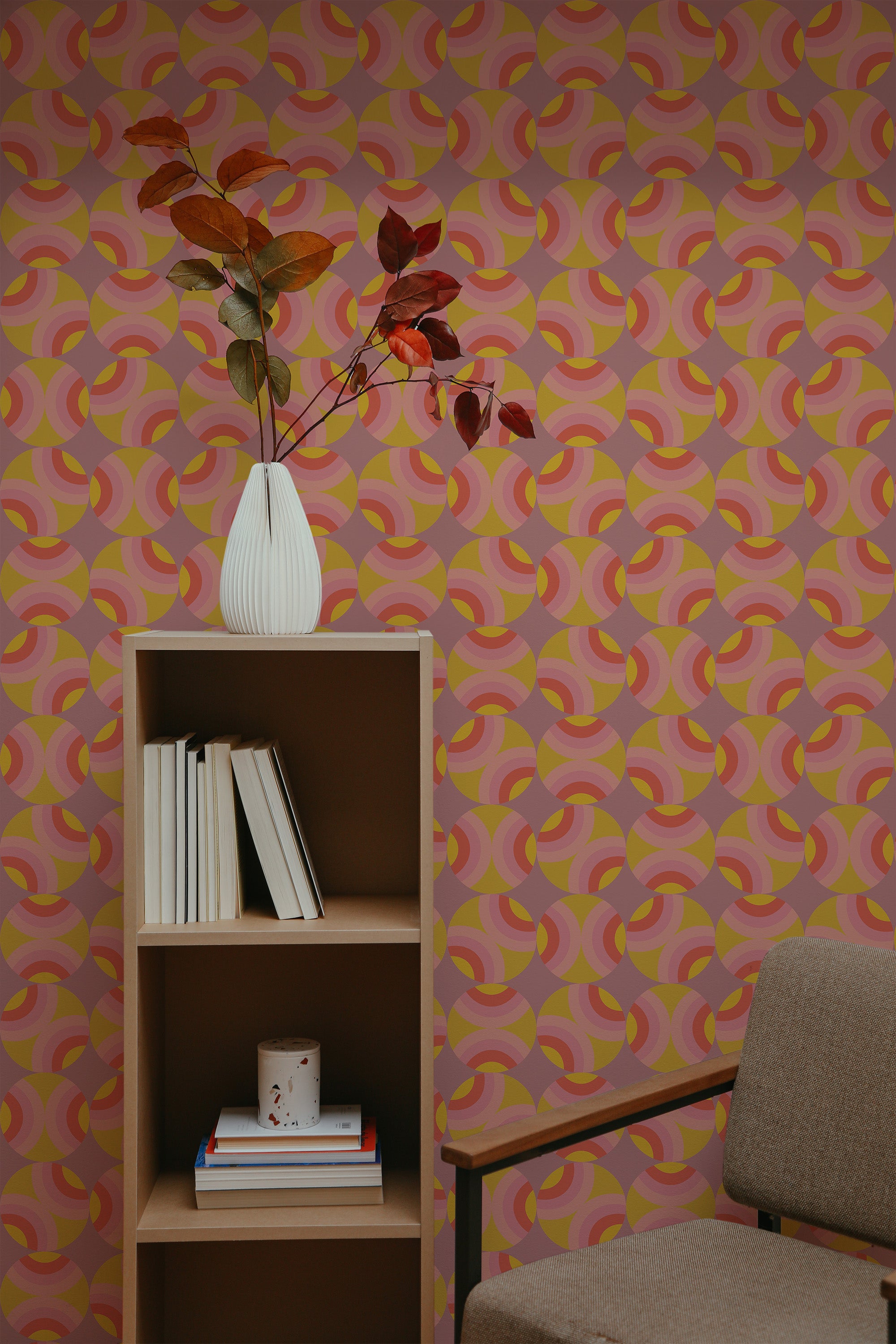 Self-adhesive retro circles wallpaper with a pattern of overlapping rings in shades of pink, yellow, and orange on a room wall.