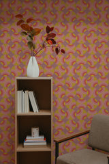 Self-adhesive retro circles wallpaper with a pattern of overlapping rings in shades of pink, yellow, and orange on a room wall.