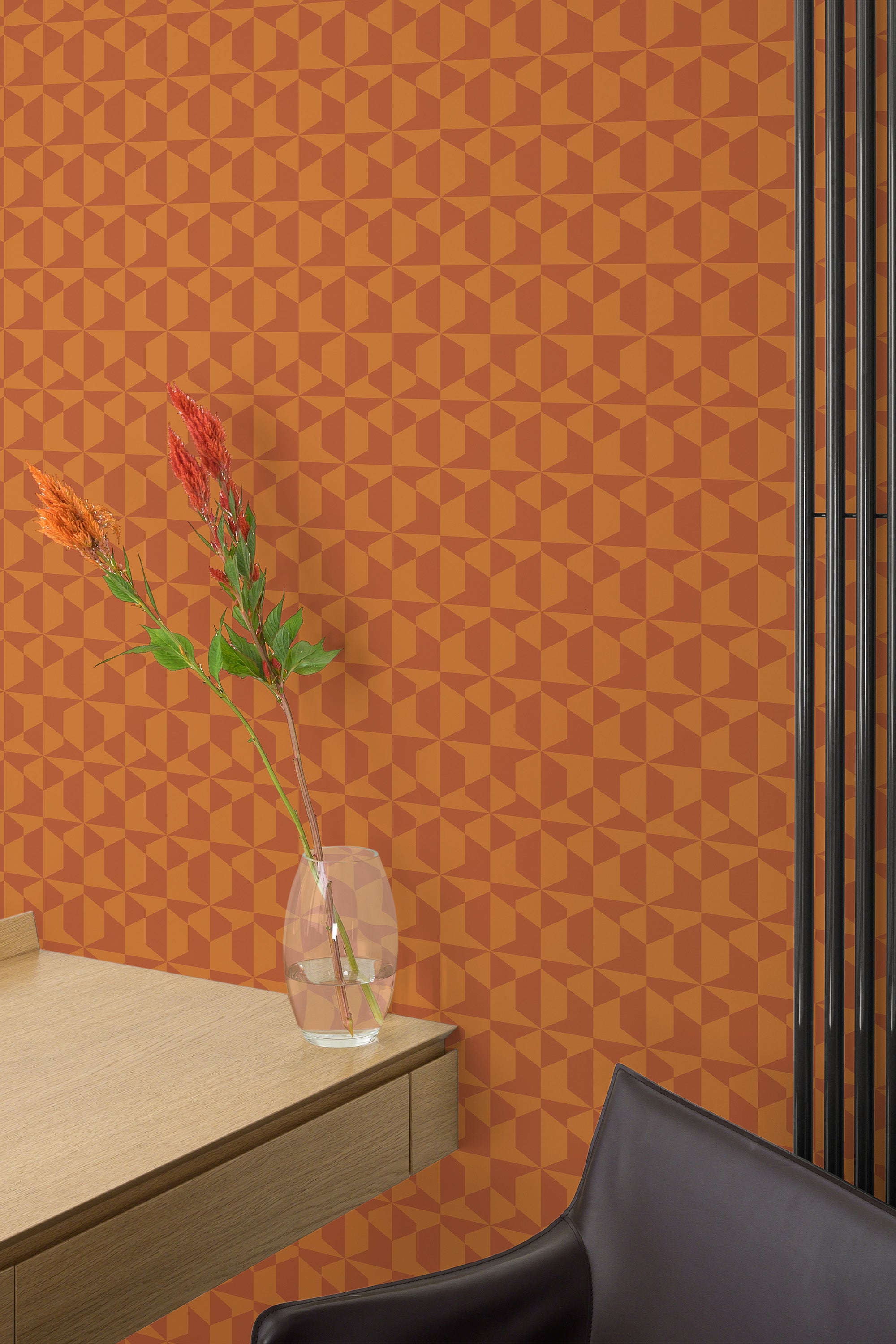 Self-adhesive burnt orange geometric wallpaper with repeating pattern on a room wall, complemented by modern furniture and a vase with flowers.