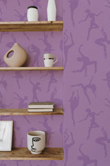 Self-adhesive purple wallpaper with silhouette patterns of ballerinas in various dance poses on the walls, complemented by wooden shelves holding decorative items.