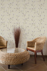 Self-adhesive wallpaper with a pattern of neutral-toned tree branches on a light background in a room with wicker furniture.