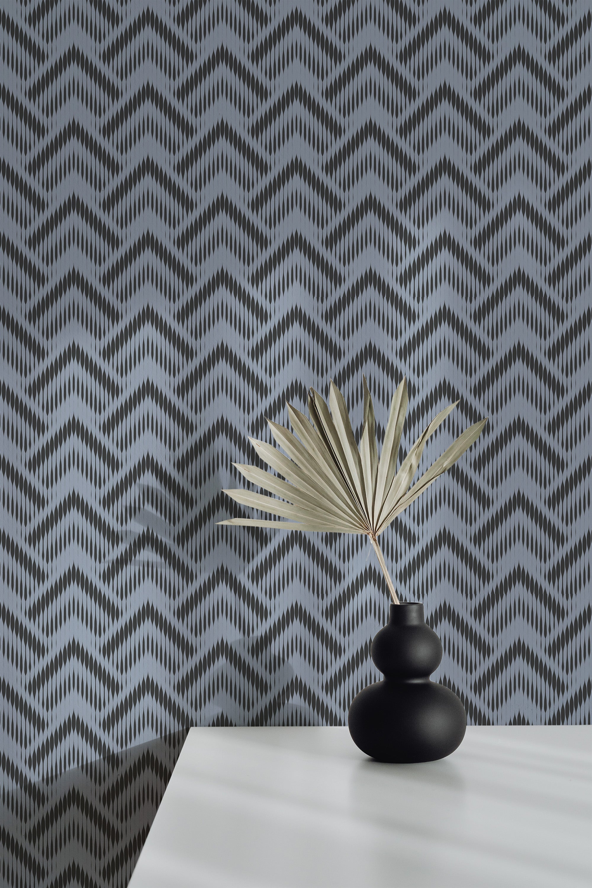 Self-adhesive abstract chevron wallpaper with zigzag patterns in shades of grey, enhancing the modern aesthetic of a room.