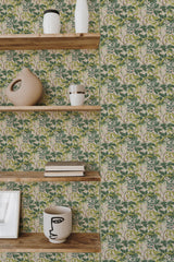 Self-adhesive wallpaper with a green and pink branch pattern on a beige background, accented by wooden shelves with decorative items.
