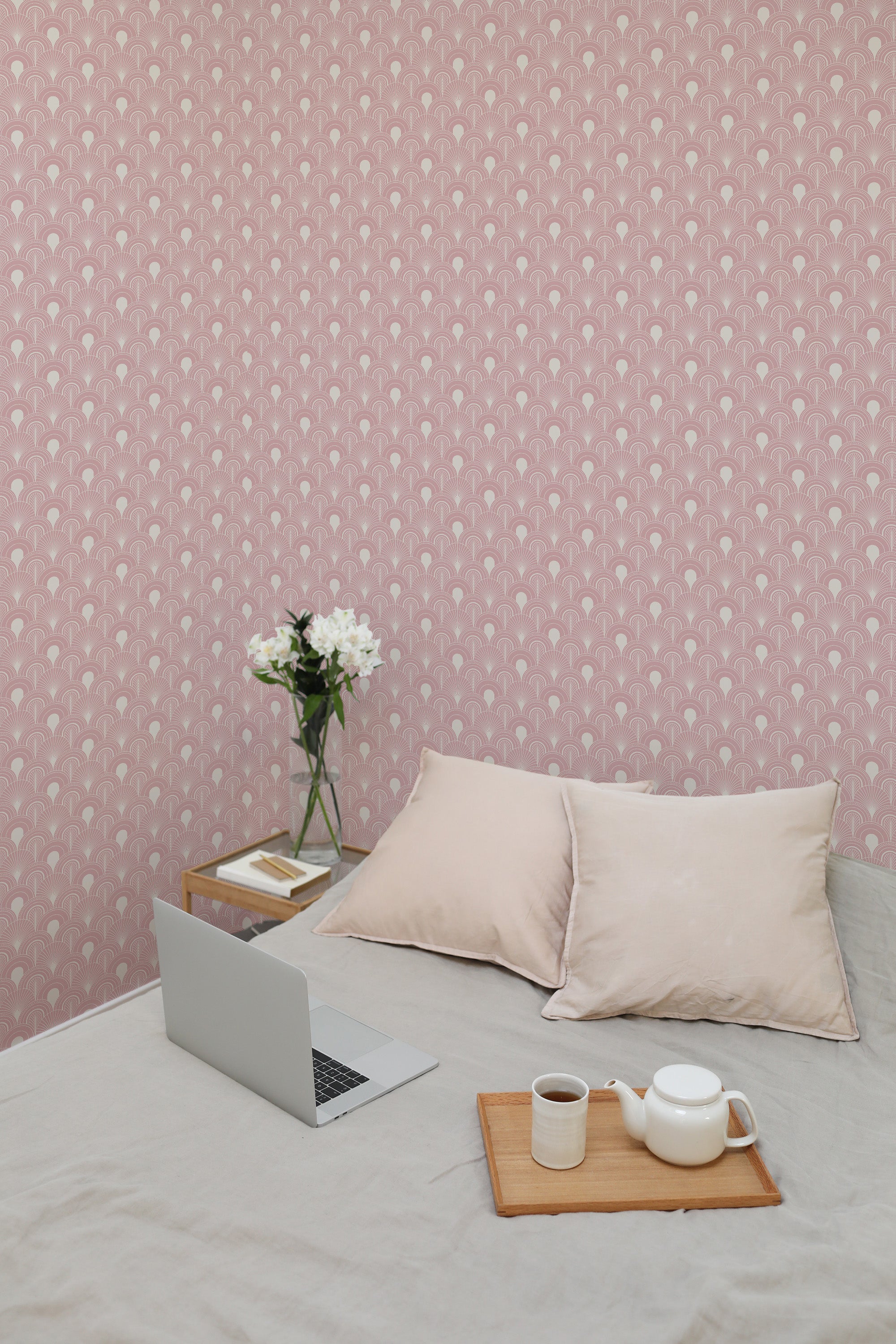Self-adhesive Art Deco-inspired wallpaper with a repeating geometric fan pattern in soft pink tones on a room wall.