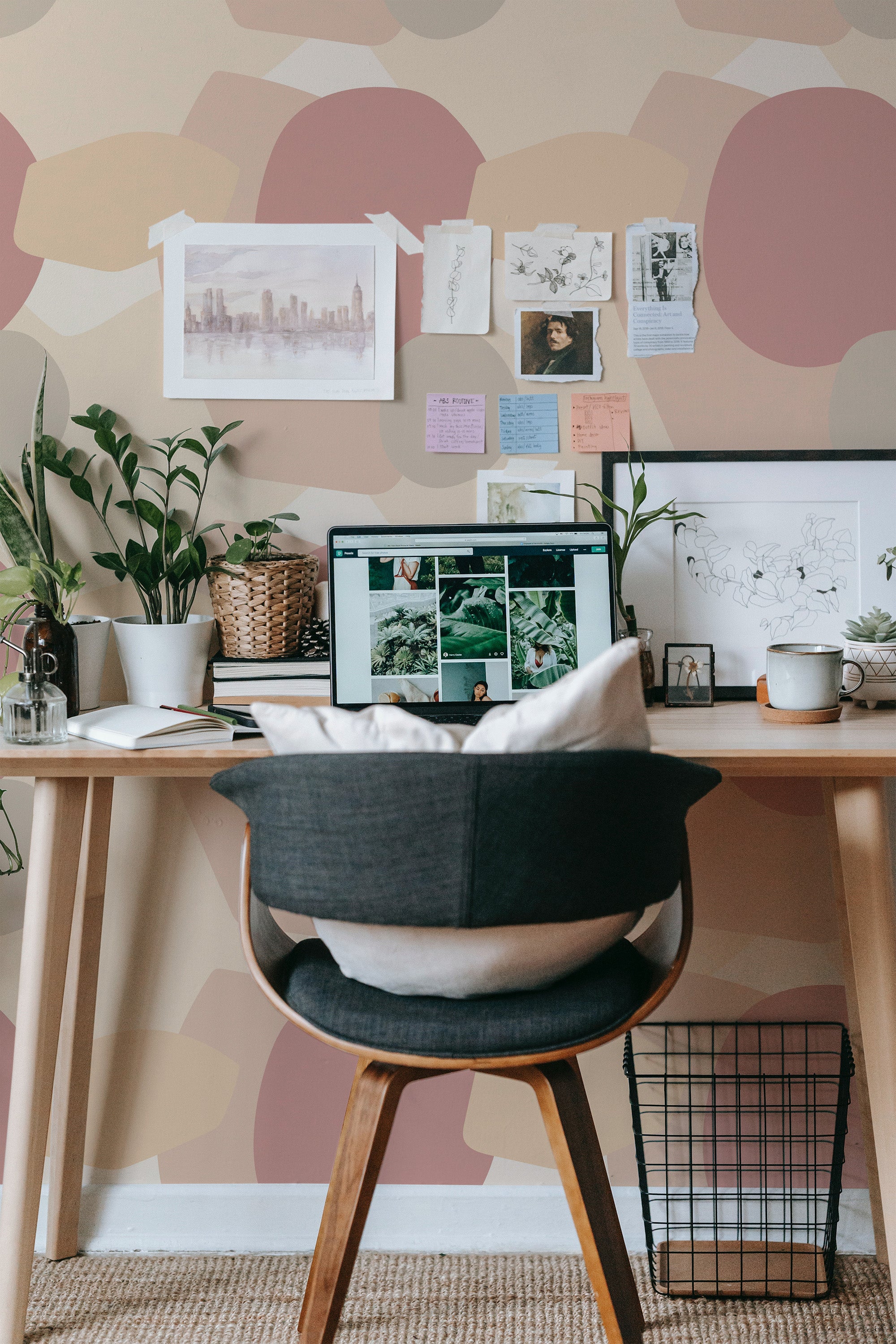Self-adhesive wallpaper with a simple boho geometry pattern of large, overlapping circles in muted tones on a home office wall, complemented by a desk with a computer setup.